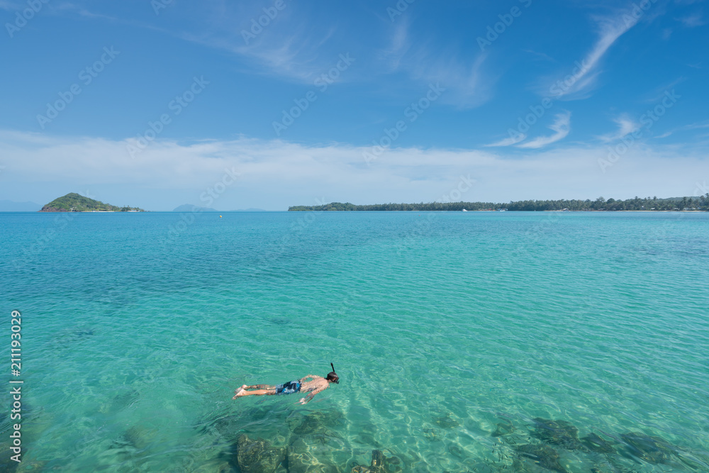 游客在泰国普吉岛热带度假胜地附近的水晶绿松石水中浮潜。夏天，瓦卡蒂