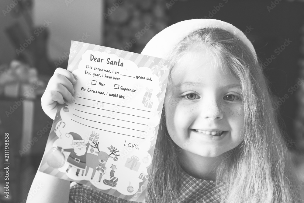 Little girl holding her Christmas wishlist