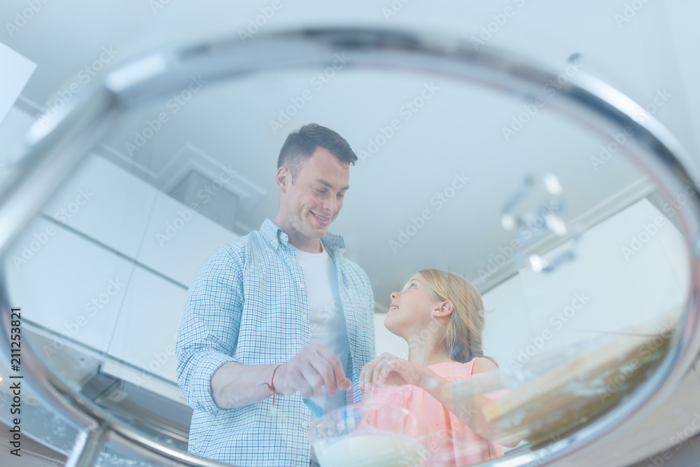 Young father and young daughter preparing a cake