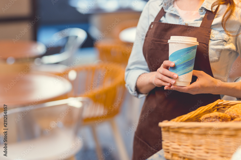 Young woman in uniform with a cup of coffee