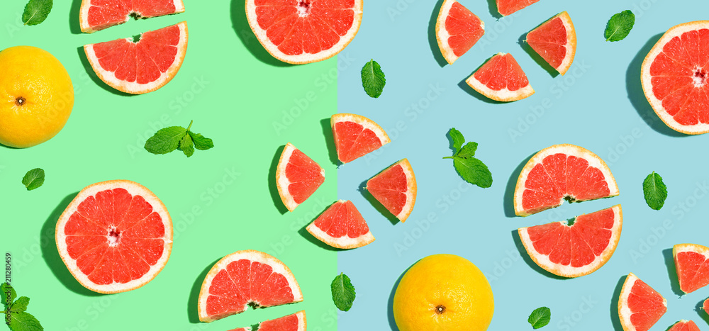 Halved fresh grapefruits on bright color background