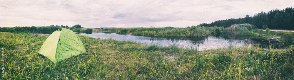 Tent on the river bank on a cloudy day