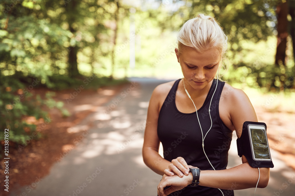 Fit young woman syncing her sports watch before a run