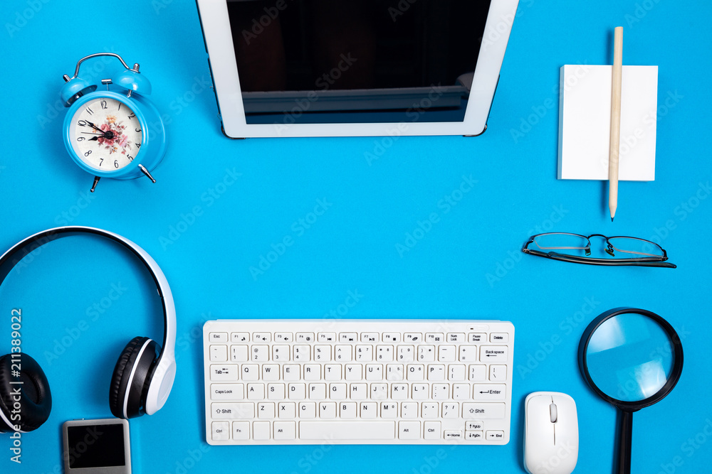 Top view of business objects on blue table in business office.