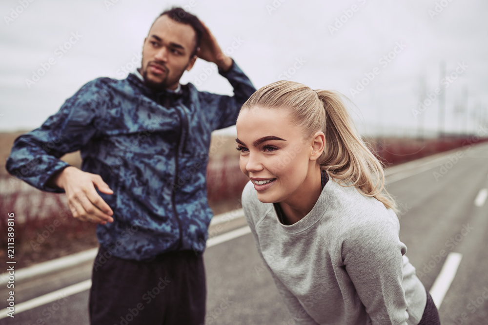 Smiling young couple preparing for an outdoor run together