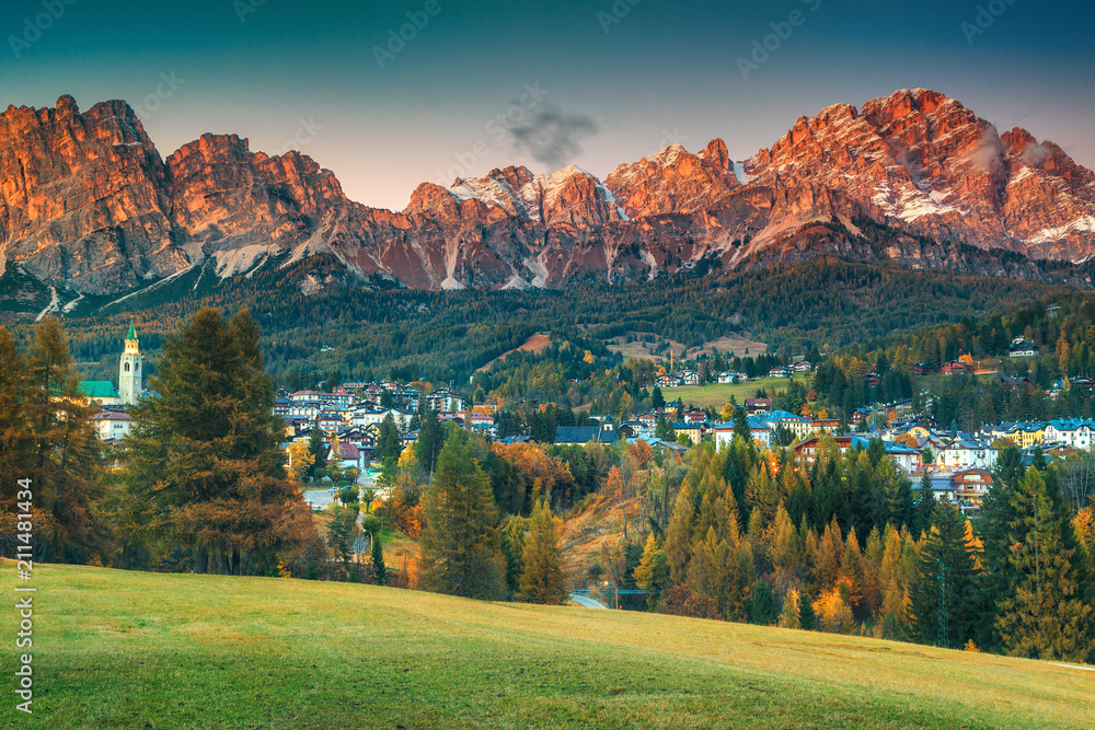 Majestic alpine cityscape with high mountains at sunset, Dolomites, Italy