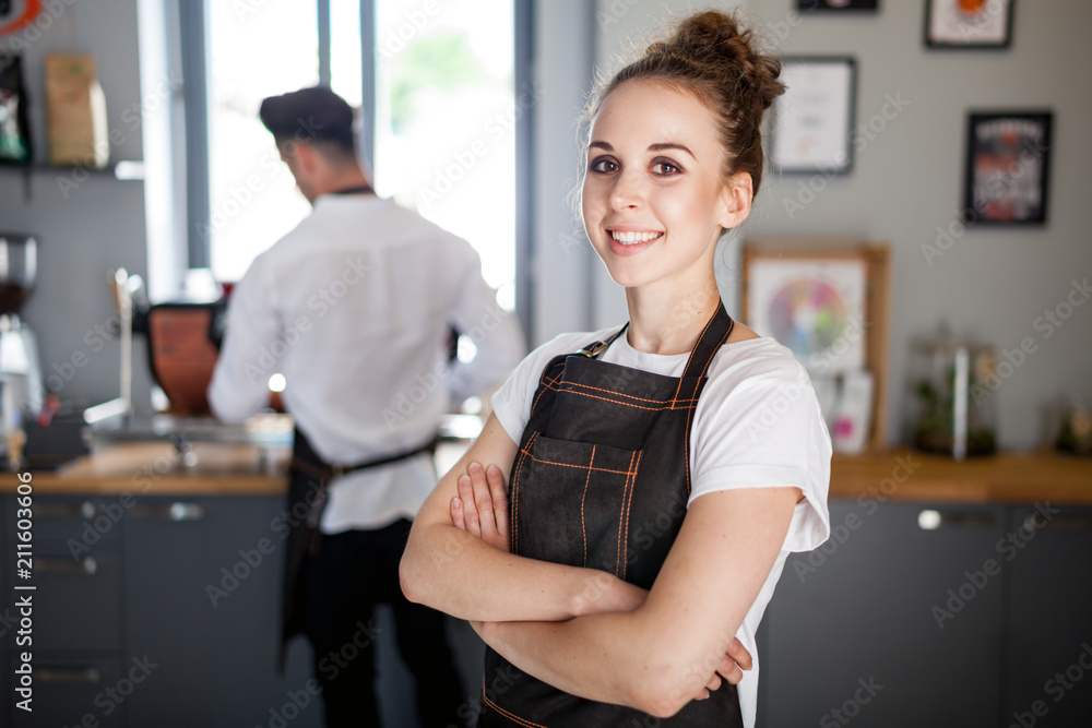 穿着围裙微笑的女咖啡师，咖啡企业主