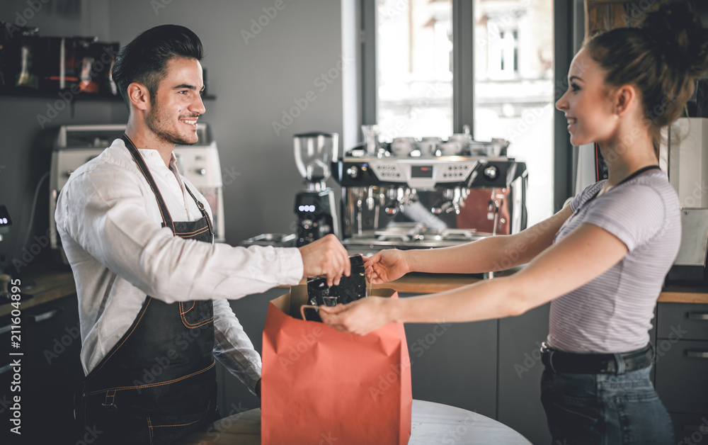 Happy customer taking paper bag after shopping at coffee shop