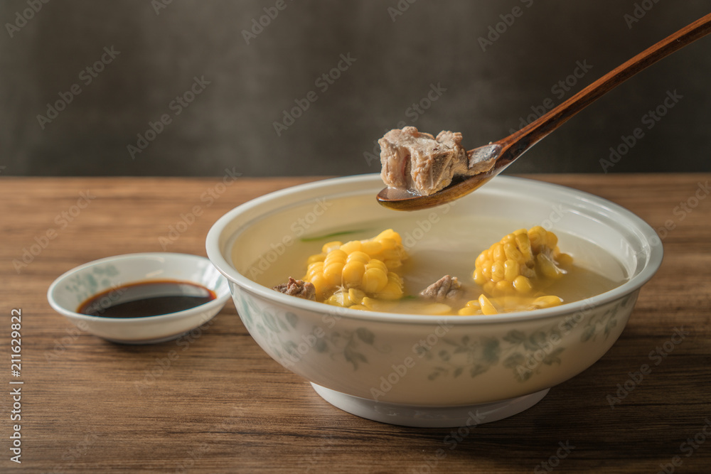 Corn bone soup, wood grain background