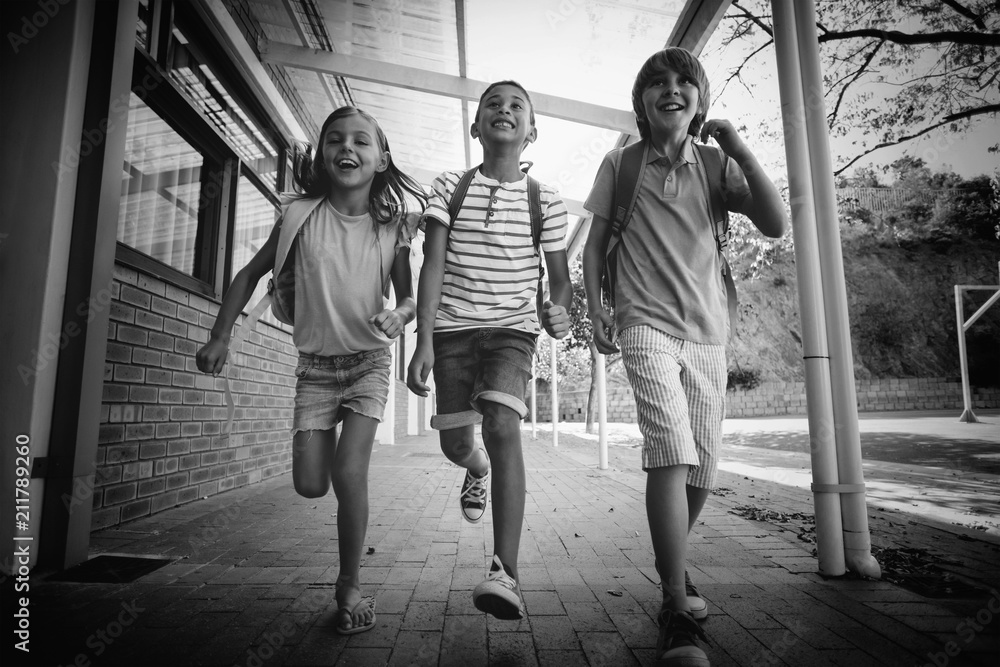 Happy school kids running in corridor