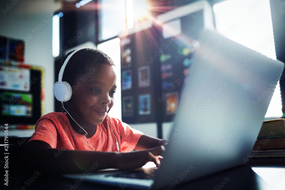 Boy listening music while using laptop