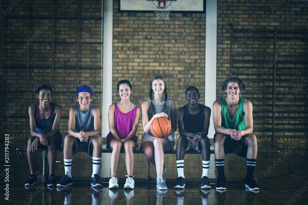 High school kids sitting on a bench in basketball court