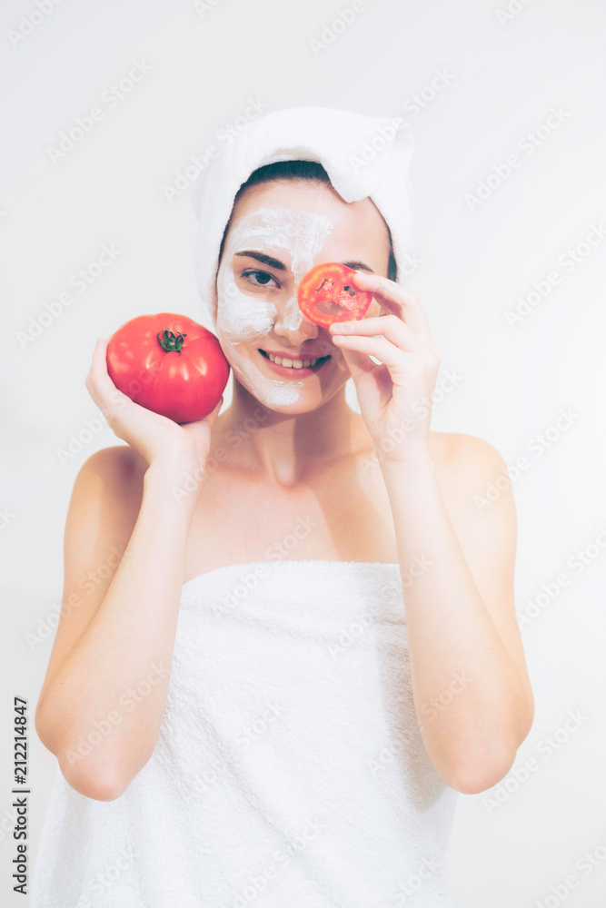 Woman get facial mask with tomato cream extract.