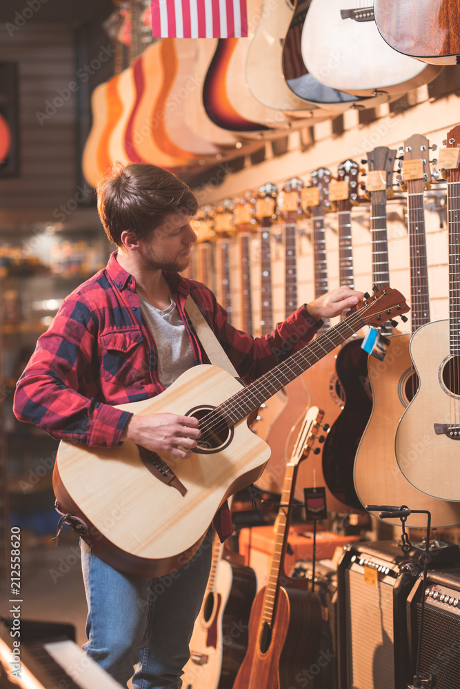 Young musician with a guitar indoors