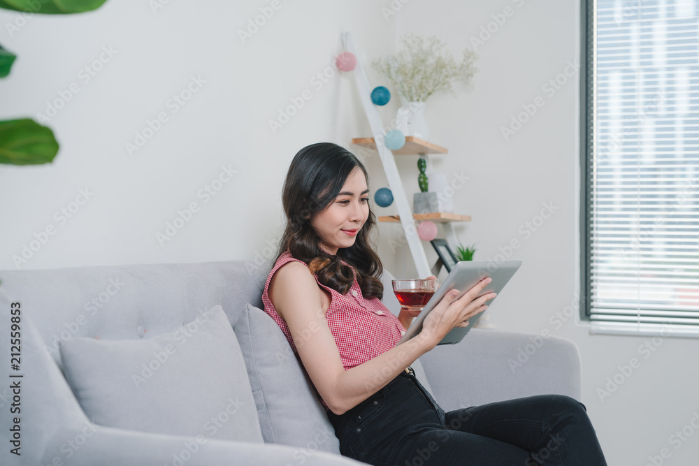 Lifestyle scene of young attractive Asian woman writing journal on notebook beside window in morning