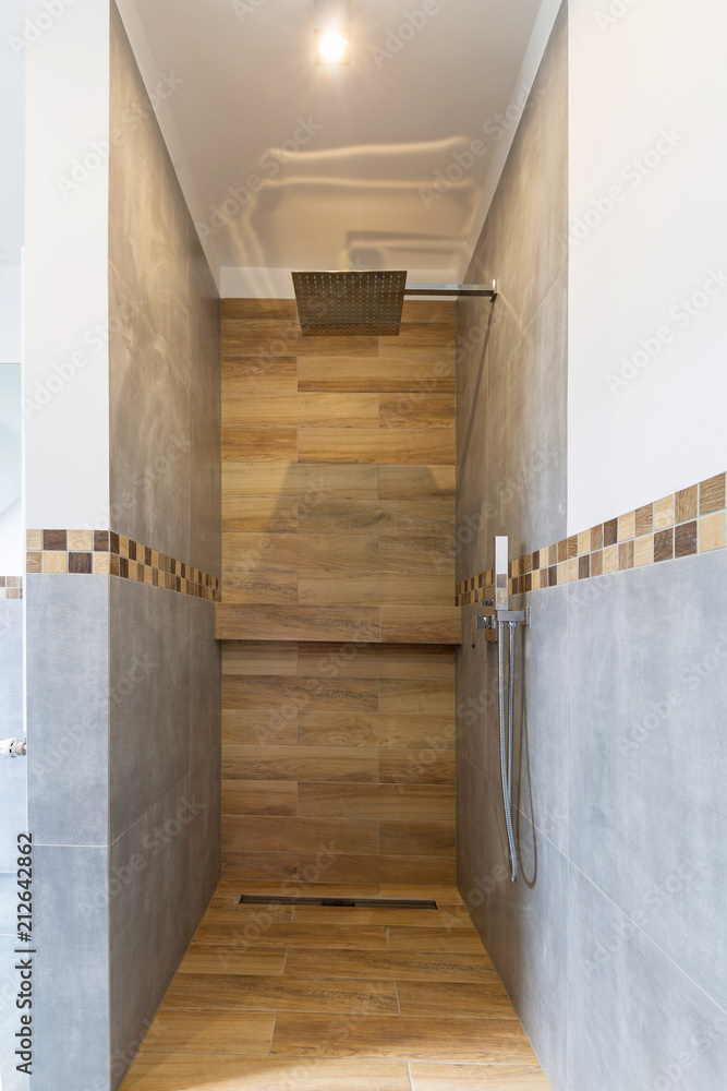 New bathroom interior in the house. Gray concrete tiles with wooden decor.