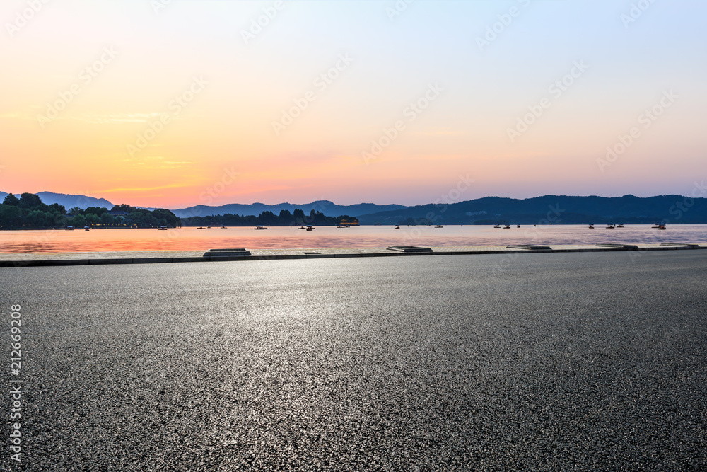 日落时空旷的柏油路和山丘的剪影