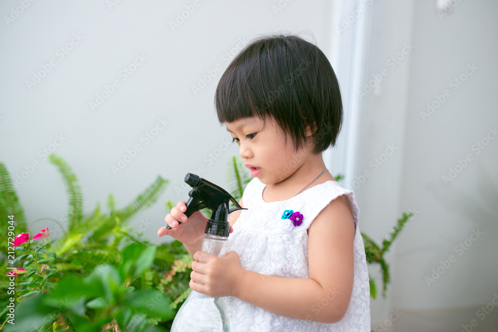 孩子在照顾植物。可爱的小女孩在浇花