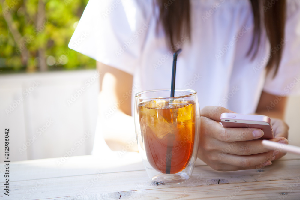 ドリンクを飲みながら、スマートフォンを操作している女性たち。