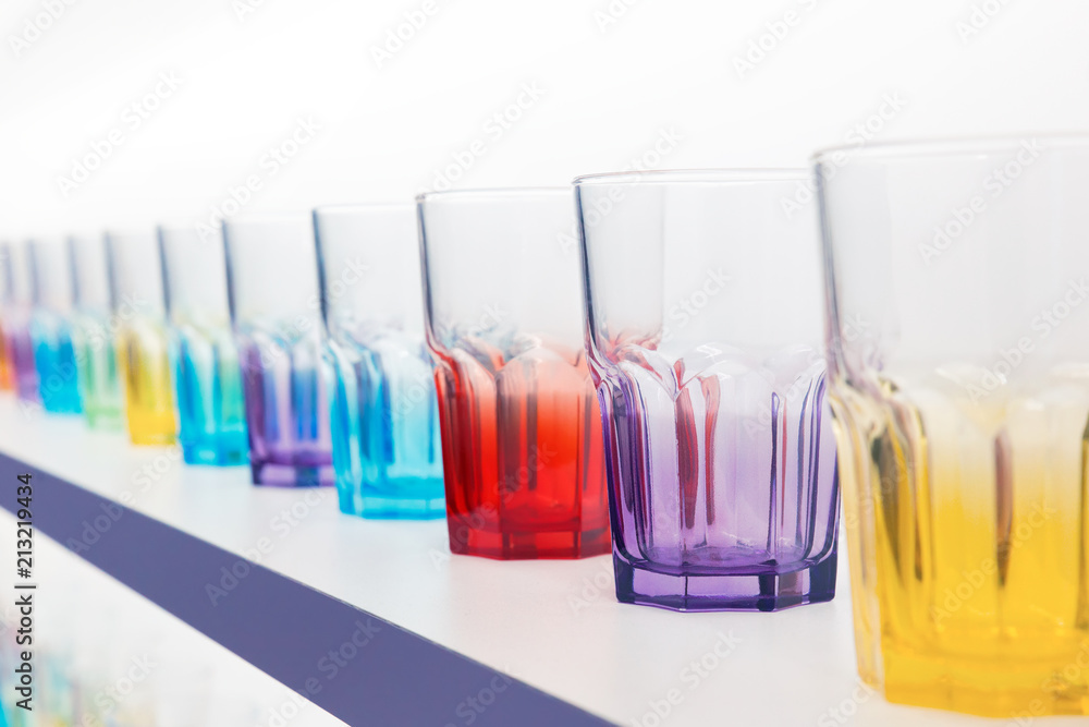 Many empty coloured Glasses  in a row on a bar