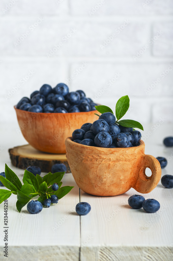 Blueberries with leaves in a clay cup