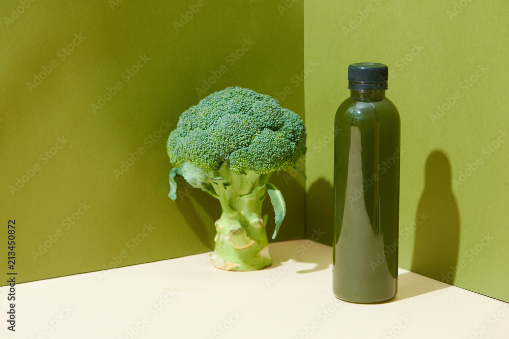 Bottle of the fresh broccoli juice on table. Healthy drink.