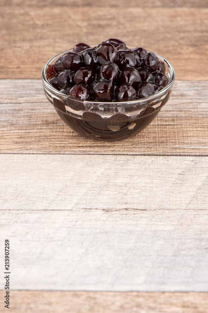 Tapioca Pearl , Bubble topping for tea or other beverage, in a cup, place on wooden table. Copy spac