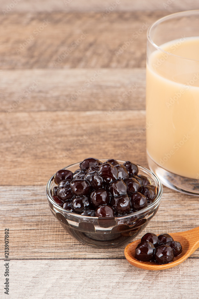 Tapioca Pearl , Bubble topping for tea or other beverage, in a cup, place on wooden table. Copy spac