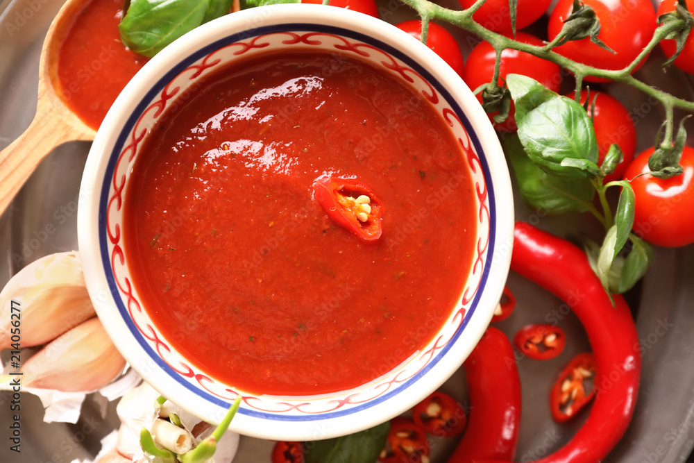 Bowl with tasty tomato sauce on table, top view