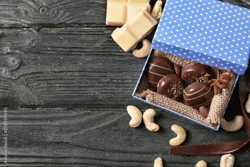 Box with yummy chocolate candies on wooden table