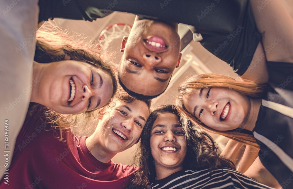 Group of teenager friends on a basketball court teamwork and togetherness concept