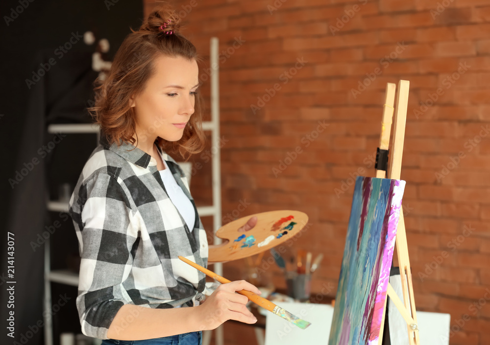 Female artist painting in workshop