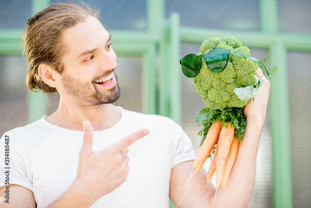 一个男人和他的蔬菜朋友用西兰花和胡萝卜做成的有趣画像。健康饮食概念