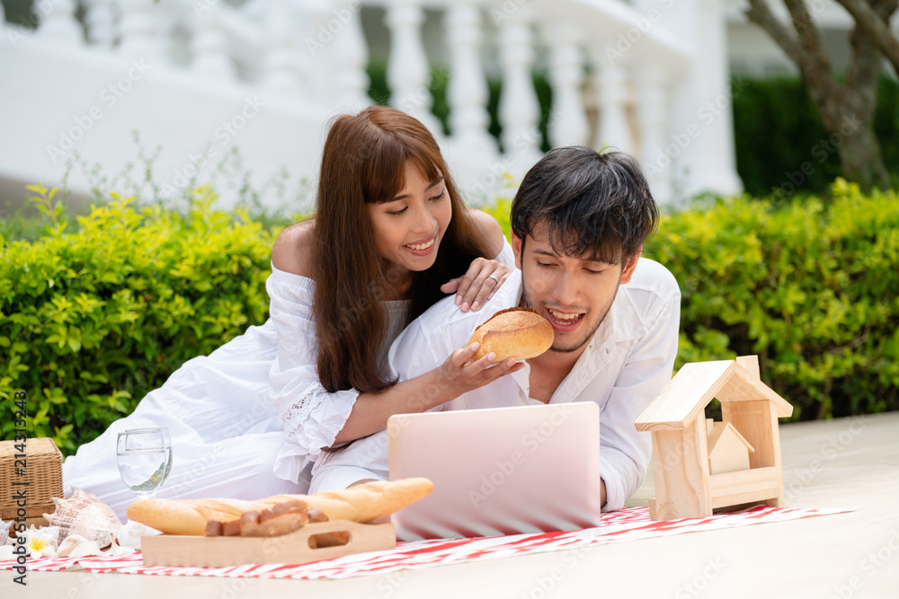 Young couple go picnic at the park in summer.