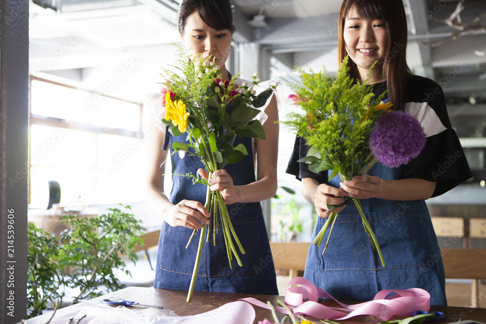 フラワーアレンジメント教室で楽しそうに花束を作る女性二人