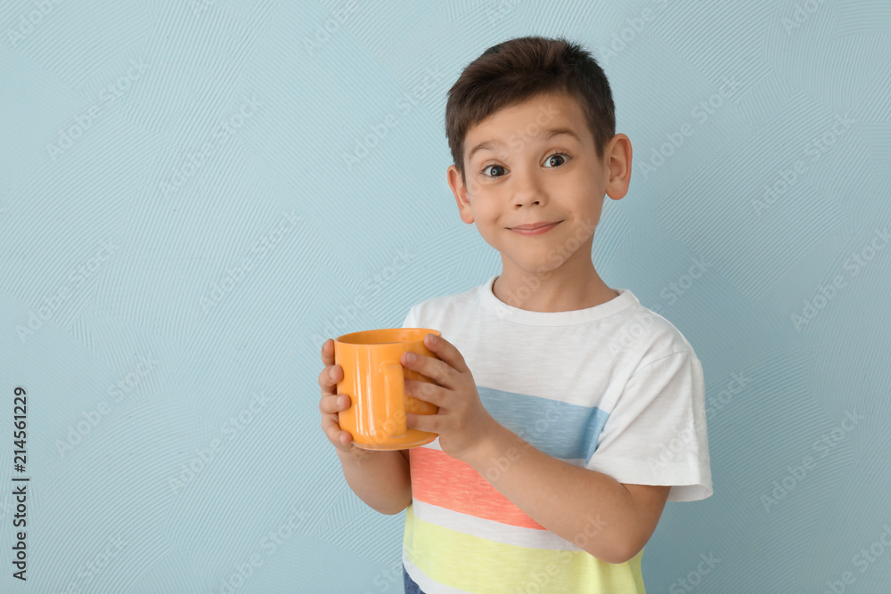 可爱的小男孩，浅背景下有一杯热可可饮料