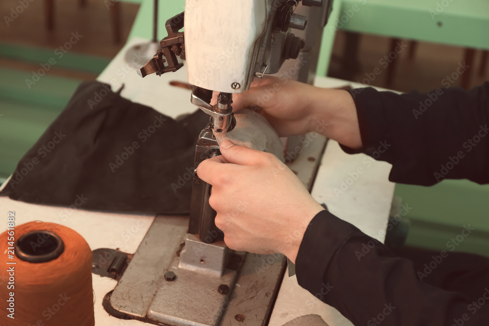 Man using sewing machine in leather workshop