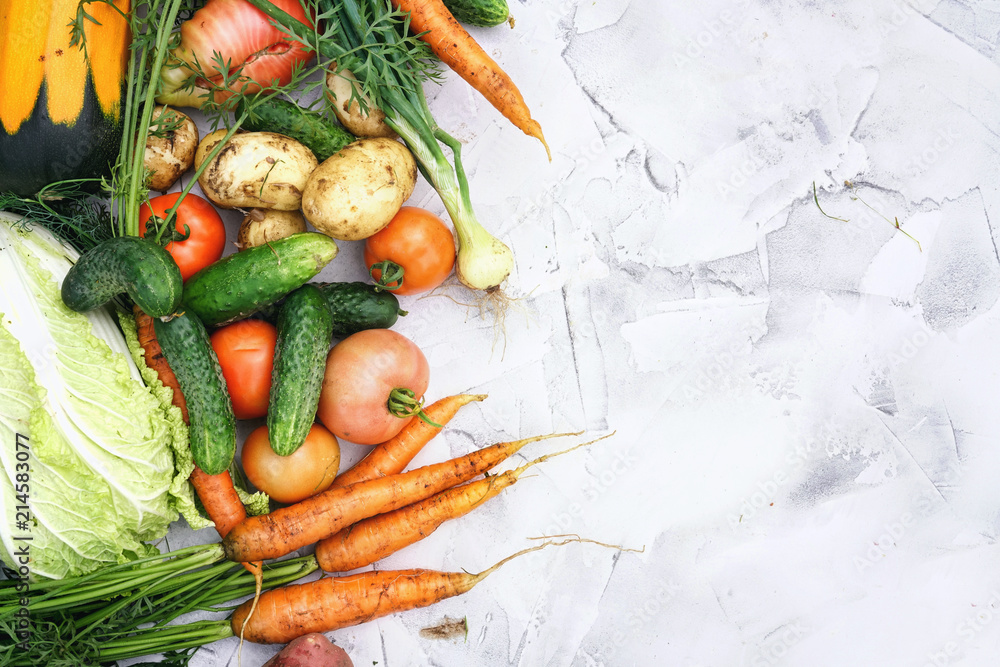 Сomposition of fresh vegetables on textured light marble table. Assortment of vegetables, potatoes, 