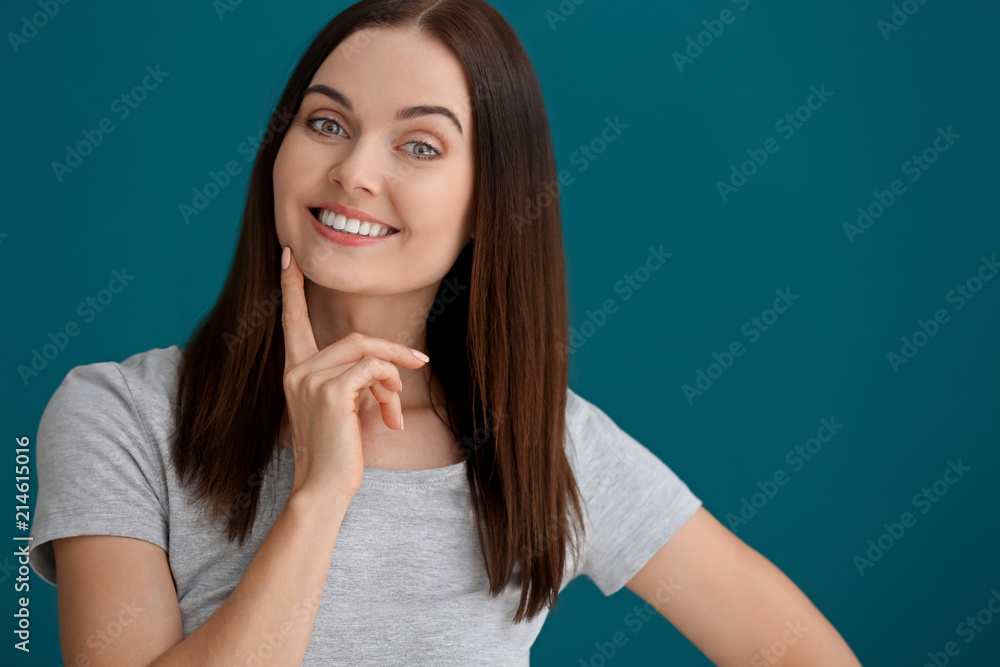 Beautiful young woman with healthy teeth on color background