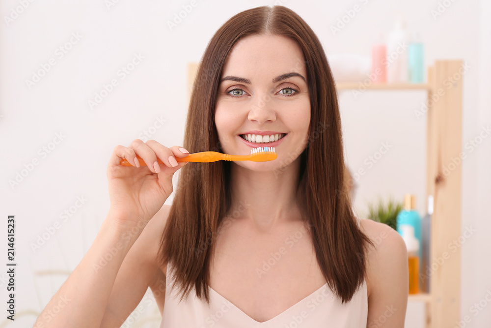 Young woman brushing her teeth in bathroom