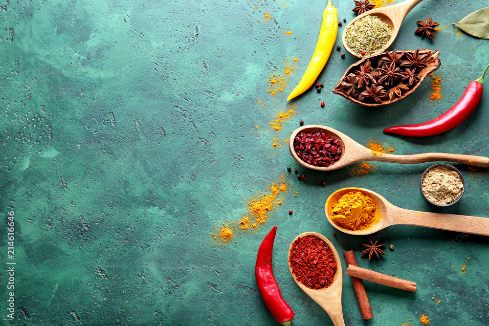 Composition with different dry spices on green background