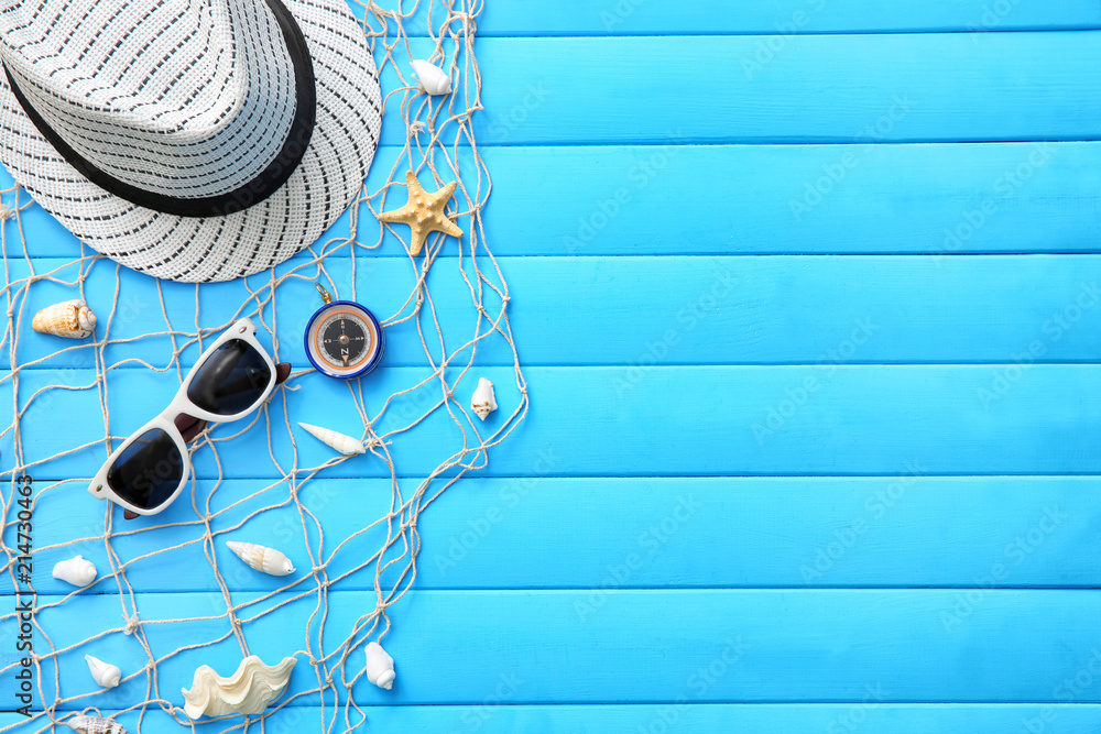 Composition with compass, net and summer accessories on color wooden background