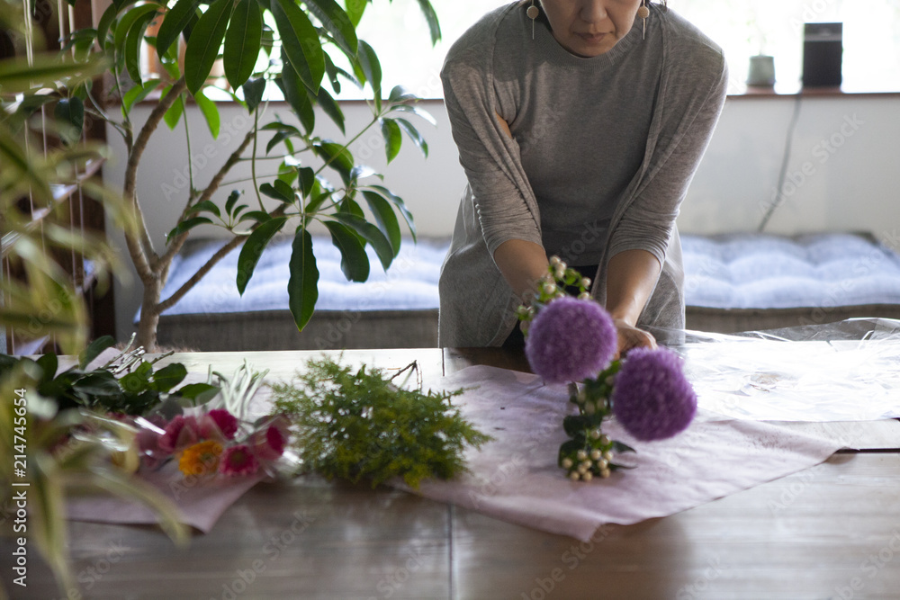 お客様にお渡しする花束を真剣に丁寧に作り上げる女性店員