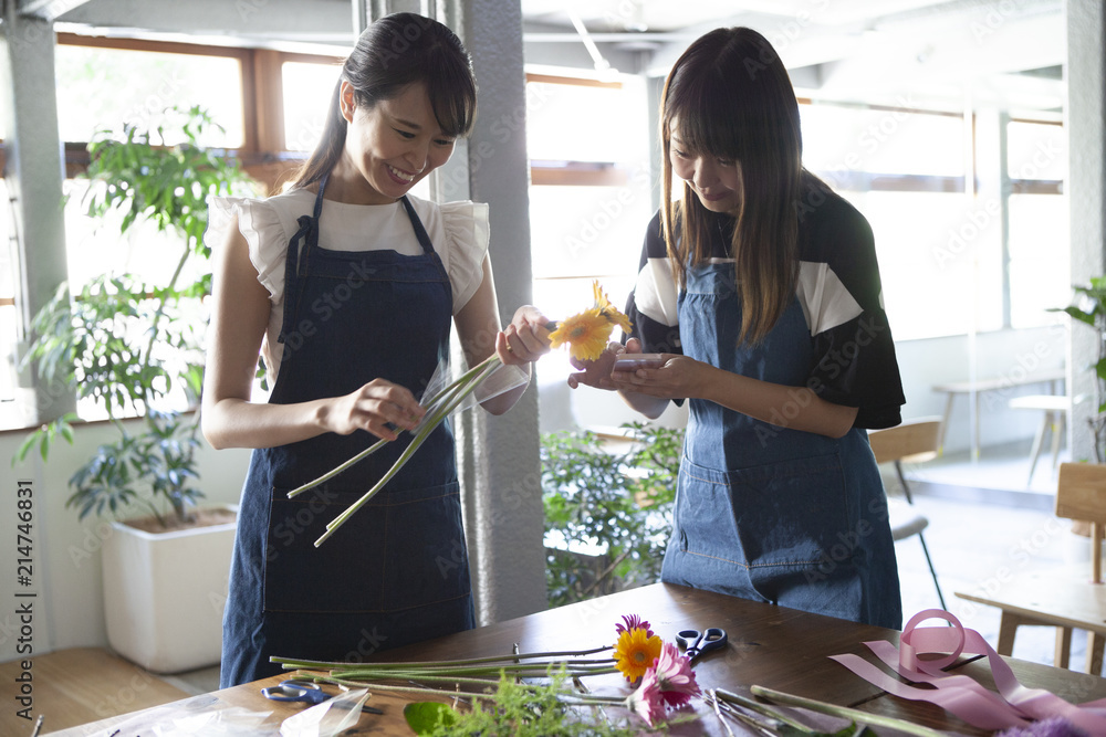 二人で話し合いながら花束を作っていく女性