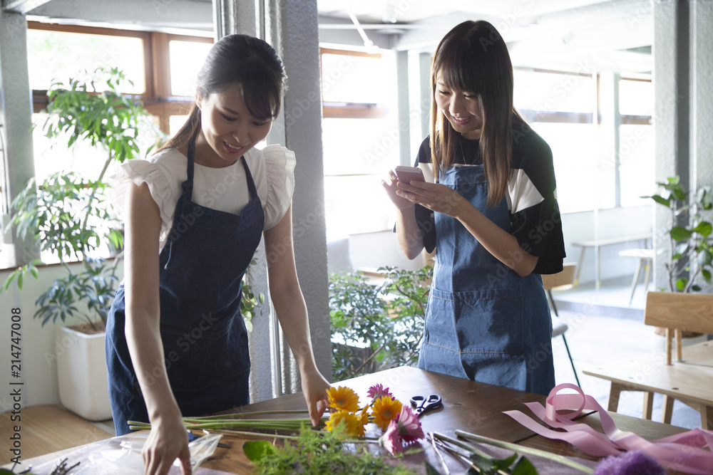 スマホでお手本を見ながら花束を作っていく女性二人