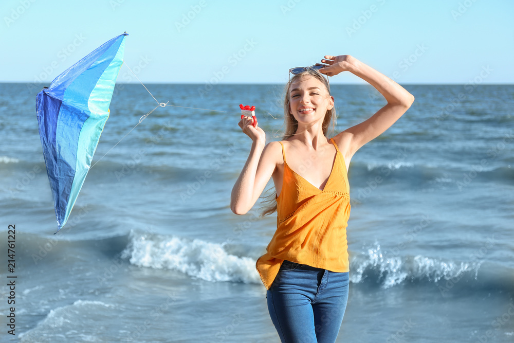 美丽的年轻女子在海边放风筝