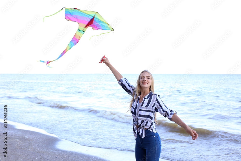 美丽的年轻女子在海边放风筝