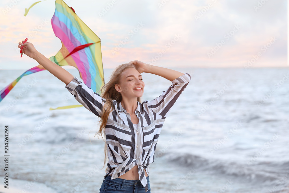 美丽的年轻女子在海边放风筝