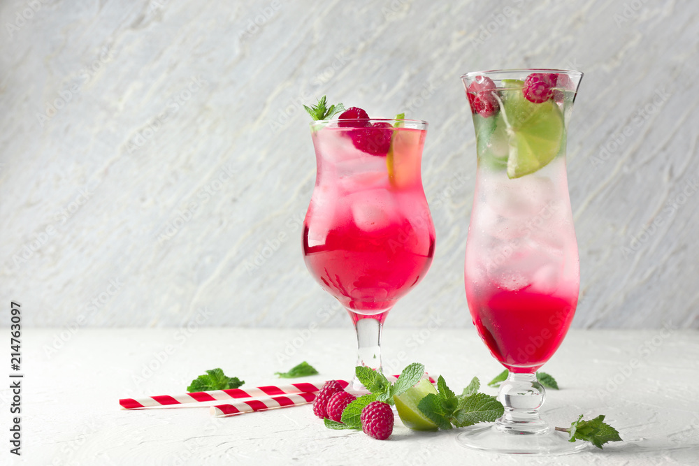 Glasses of fresh raspberry mojito on table