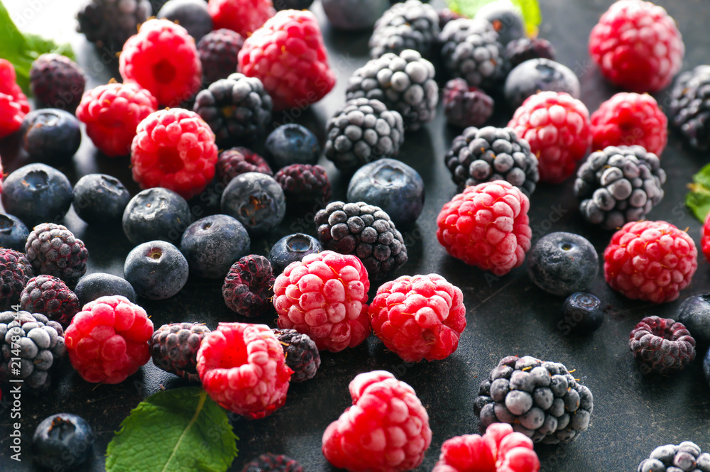 Delicious frozen berries on grey background